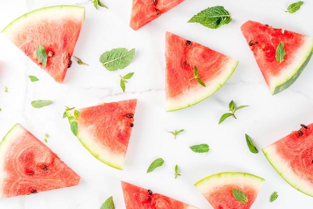 Fresh ripe juicy organic raw watermelon, cut into pieces on a white marble table