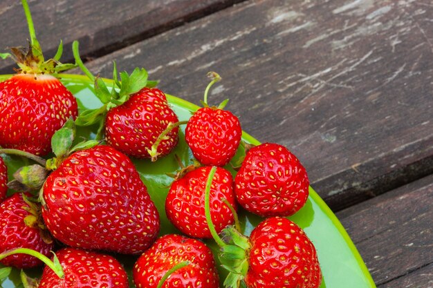 Fresh ripe juicy strawberries on the green plate