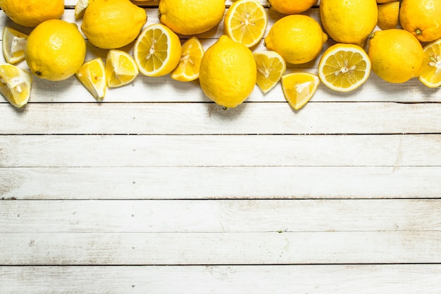 Fresh ripe lemons. On a white wooden table.