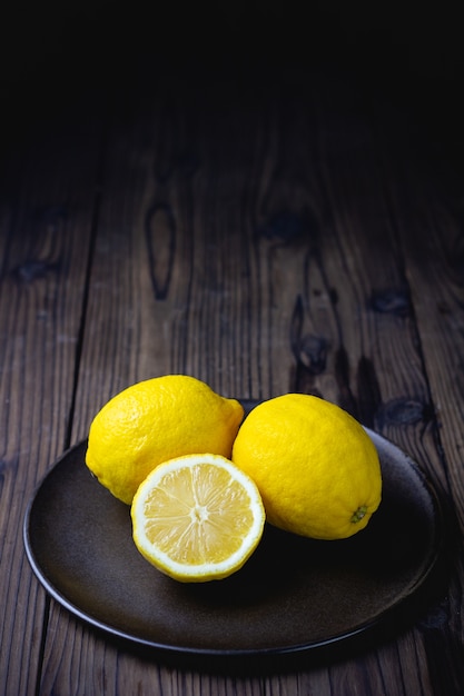 Photo fresh ripe lemons on wooden table.