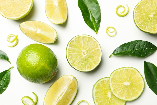 Fresh ripe limes, peel and leaves on whole background