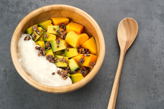 Fresh and ripe mango fruit slice on wooden bowl