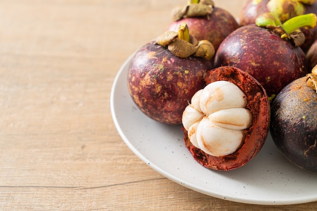 Fresh ripe mangosteen fruits on white plate