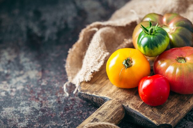 Fresh, ripe multi colored tomatoes on a dark background.