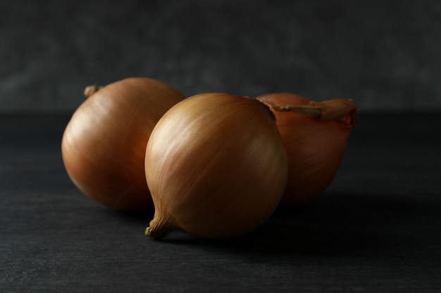 Fresh ripe onion on black wooden table