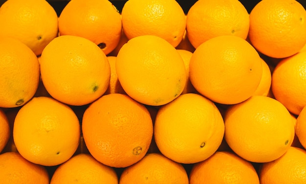 Fresh and ripe orange in a box on a shelf in a grocery store