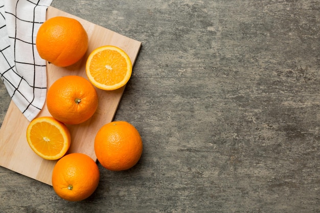 Fresh ripe oranges on cutting board on table Top view Flat lay