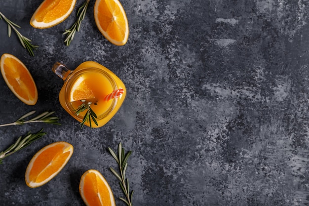 Fresh ripe oranges and juice on stone table.