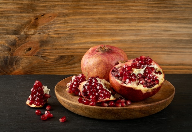 Fresh Ripe Organic Pomegranate Fruit with Juicy Seeds on Rustic Tablecloth Burlap surface with Copy Space. Still Life in Village Style