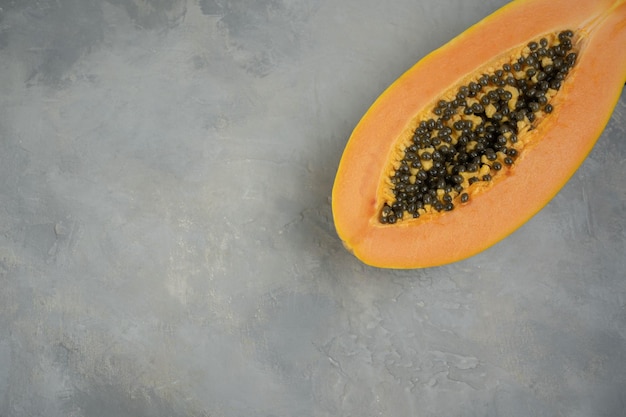 Fresh ripe papaya fruits on grey table closeup