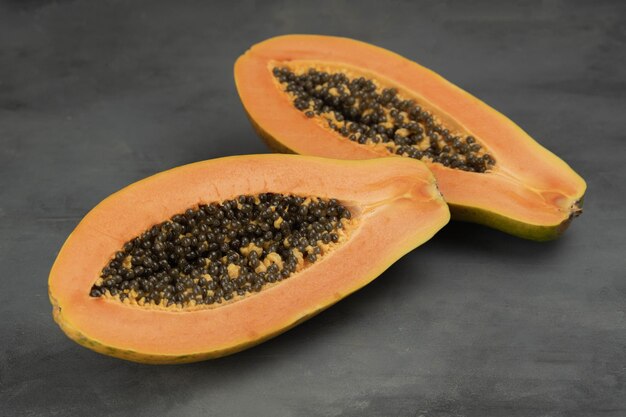 Fresh ripe papaya fruits on grey table closeup