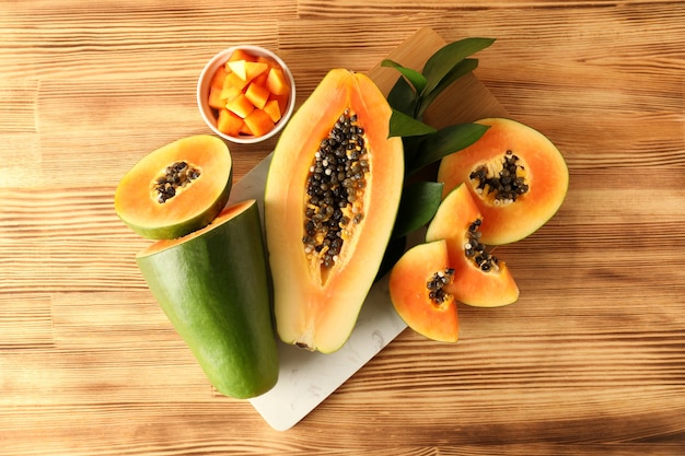 Fresh ripe papaya on light wooden table