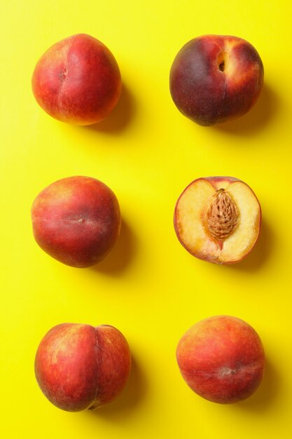 Fresh ripe peach fruits on yellow background