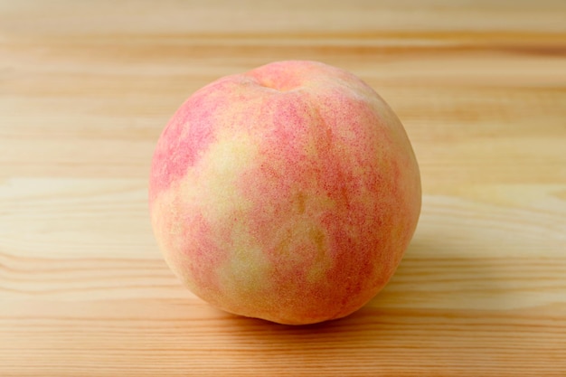 Fresh ripe peach isolated on wooden background