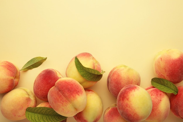 Fresh ripe peaches on beige background top view