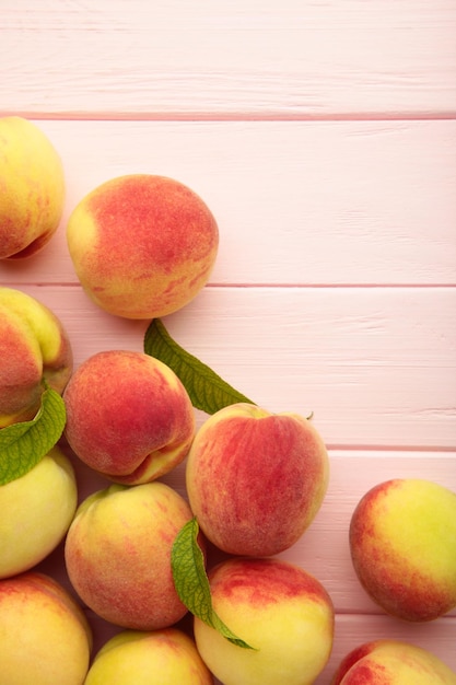Fresh ripe peaches on pink background top view Vertical photo