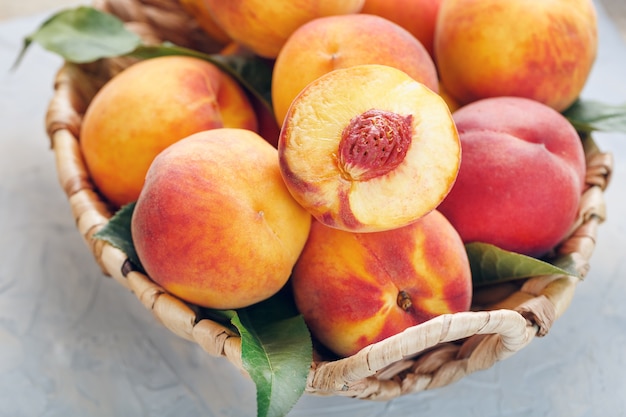 Fresh ripe peaches in a wicker basket