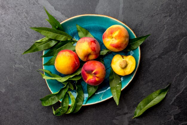 Fresh ripe peaches with peach tree leaves