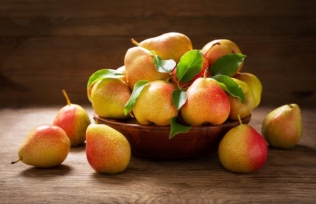 Fresh ripe pears with leaves in a bowl