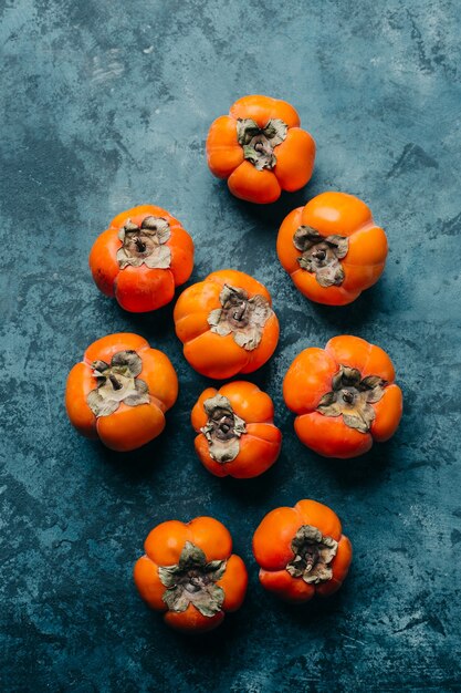 Fresh ripe persimmon on blue .