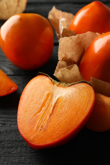 Fresh ripe persimmon on wooden background, close up