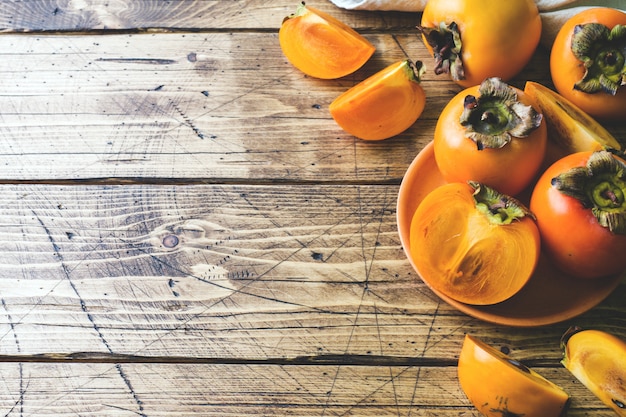 Fresh ripe persimmon on a wooden table