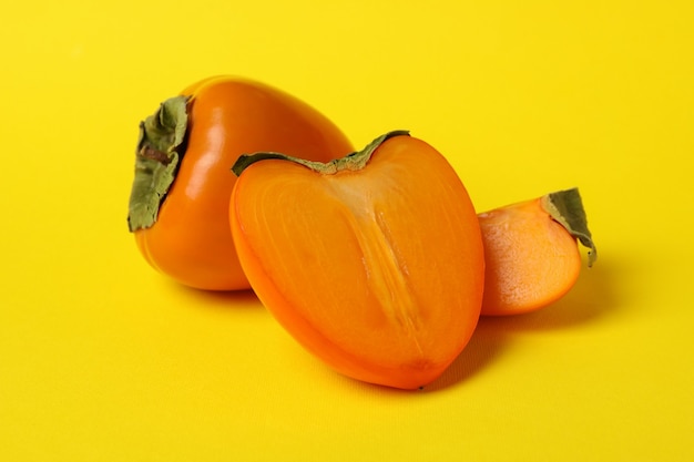 Fresh ripe persimmon on yellow