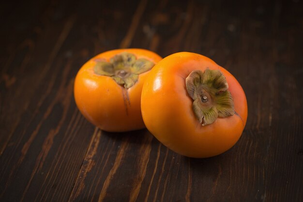 fresh ripe persimmons on a dark background