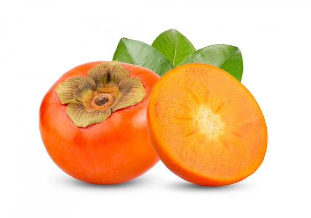 Fresh ripe persimmons with leaves on white wall.