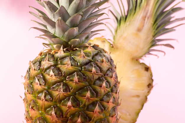 Ananas maturo fresco contro uno sfondo rosa. ciao, banner concetto estivo.