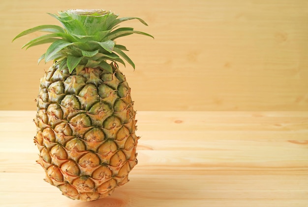 Ananas maturo fresco isolato su sfondo di legno