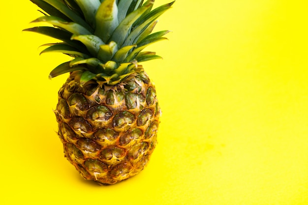 Foto ananas maturo fresco su giallo.