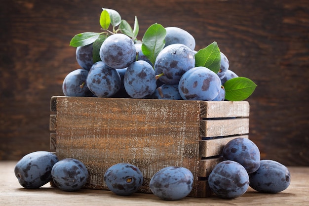 Fresh ripe plums in a wooden box