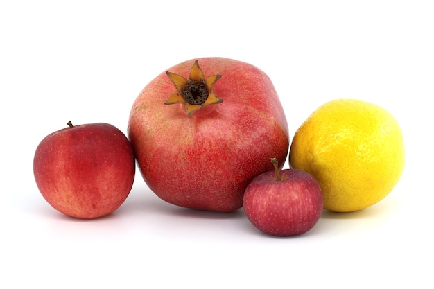 Fresh ripe pomegranate red apples and whole yellow lemon isolated on white background