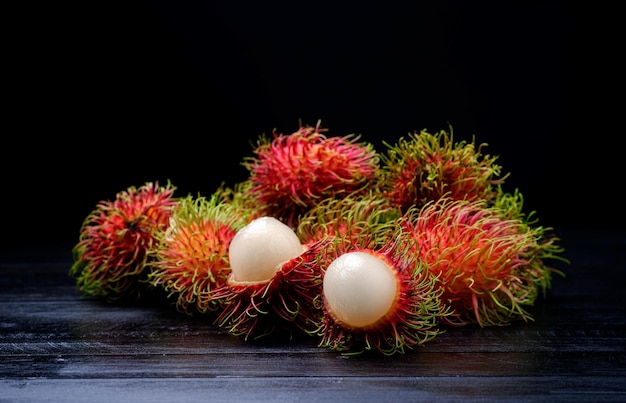 Fresh and ripe rambutan fruit with a sweet taste on black background