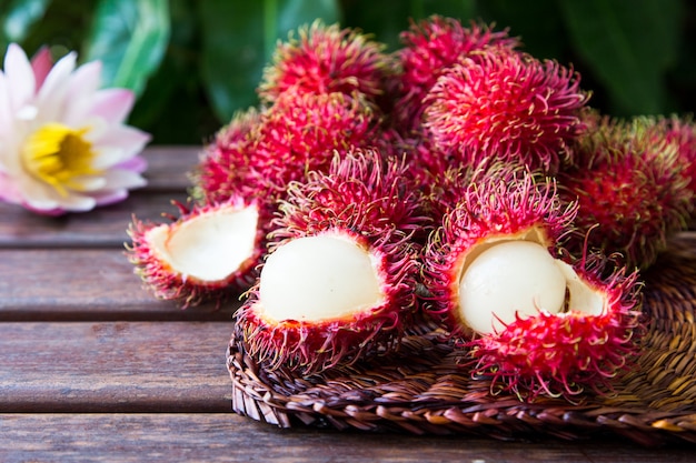 Fresh ripe rambutans on wooden background. Delicious rambutan sweet fruit