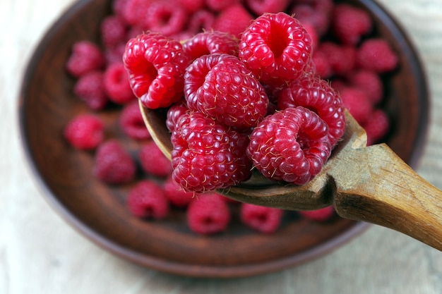 fresh ripe raspberries in a wooden spoon.