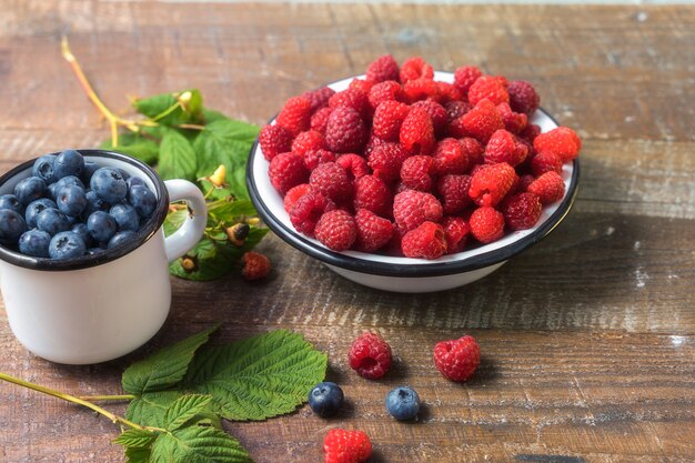 Fresh ripe raspberry and blueberry on wooden background.