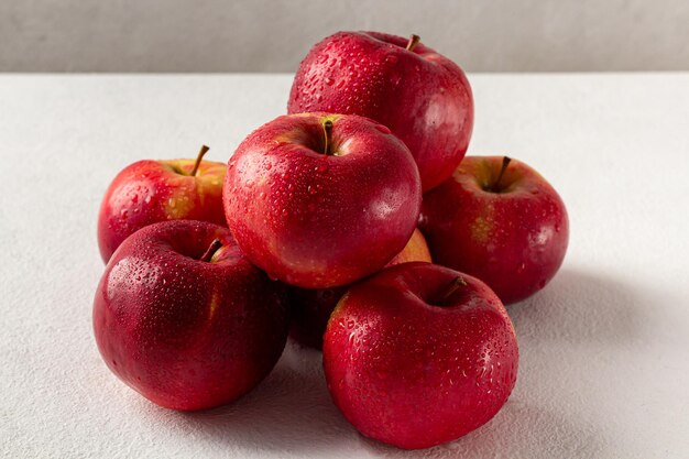 Fresh ripe red apples on a gray background side view vegetarian delicious product in the morning sun