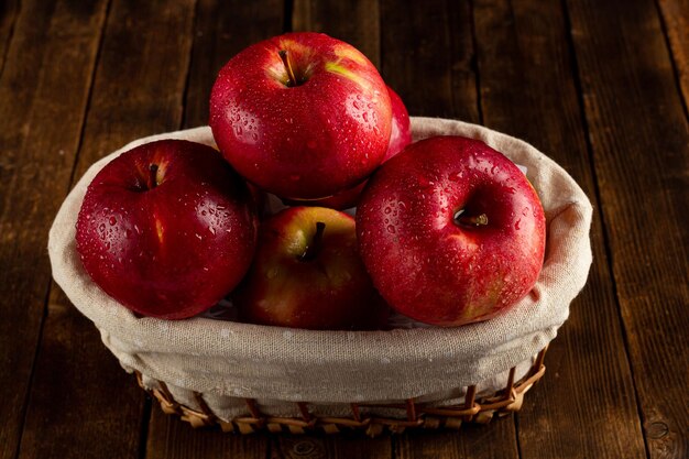 Fresh ripe red apples on a wooden table side view vegetarian\
delicious product in a rustic style
