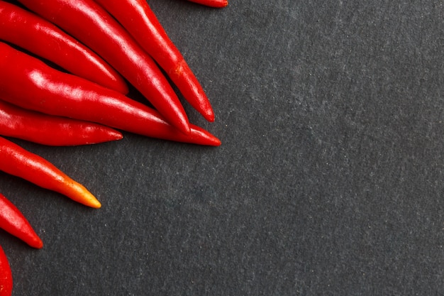 Fresh ripe red hot chili peppers on a black background