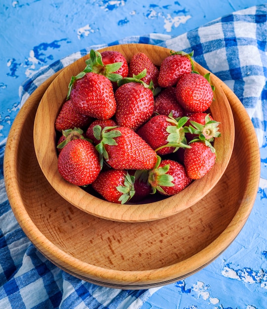 Fresh ripe red strawberry in a brown wooden plate 