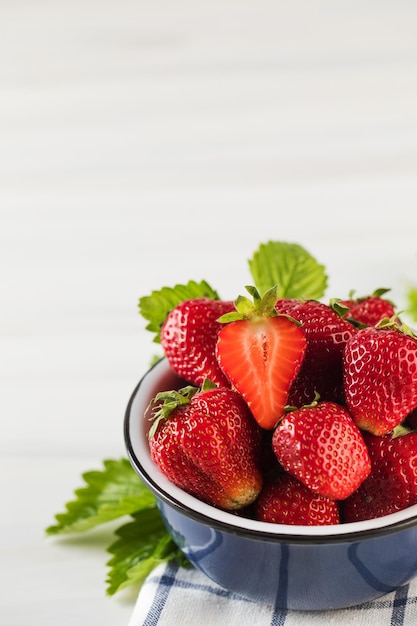 Fresh ripe strawberries in a bowl on a white background Ecoproducts