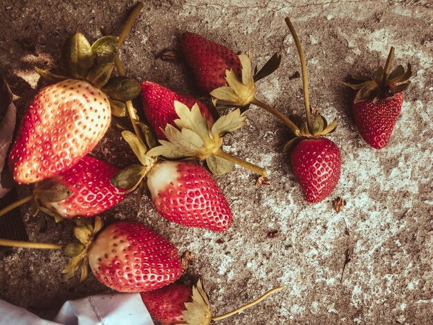 Photo fresh ripe strawberries and half a berry on a gray textured background top view with copy space