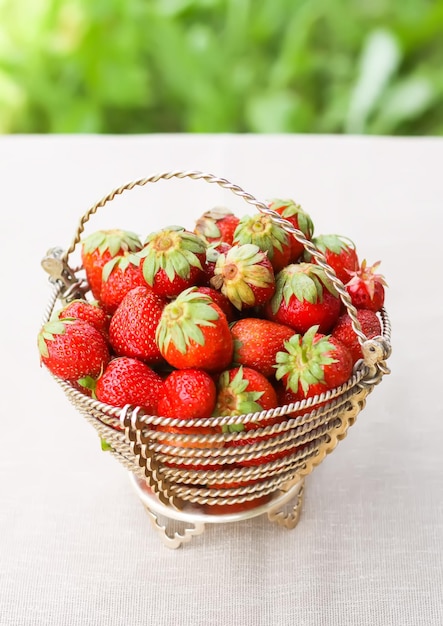 Fresh ripe strawberries in metal basket outdoors