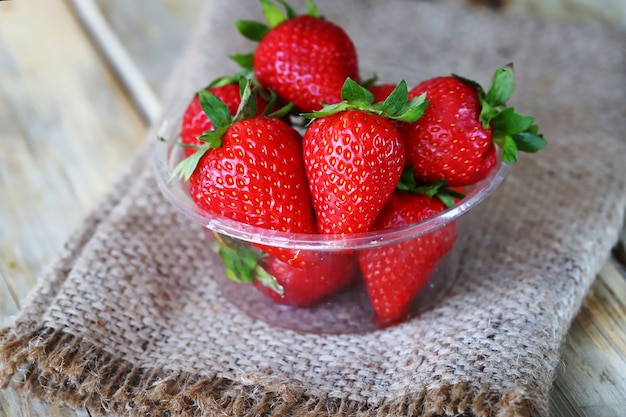 Fresh ripe strawberries in a plastic bowl