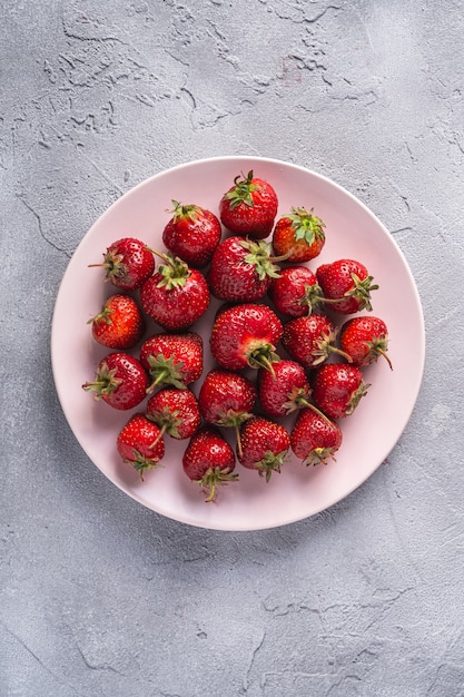 Fresh ripe strawberry fruits in pink plate