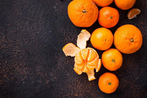 Fresh ripe tangerines on brown rusty background