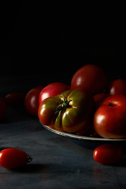 Fresh ripe tomatoes on dark background