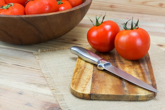 Fresh ripe tomatoes on wood background.